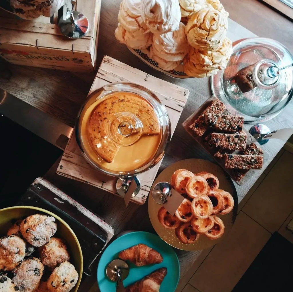 Meringues, brownies and pastries laid out on a wooden table