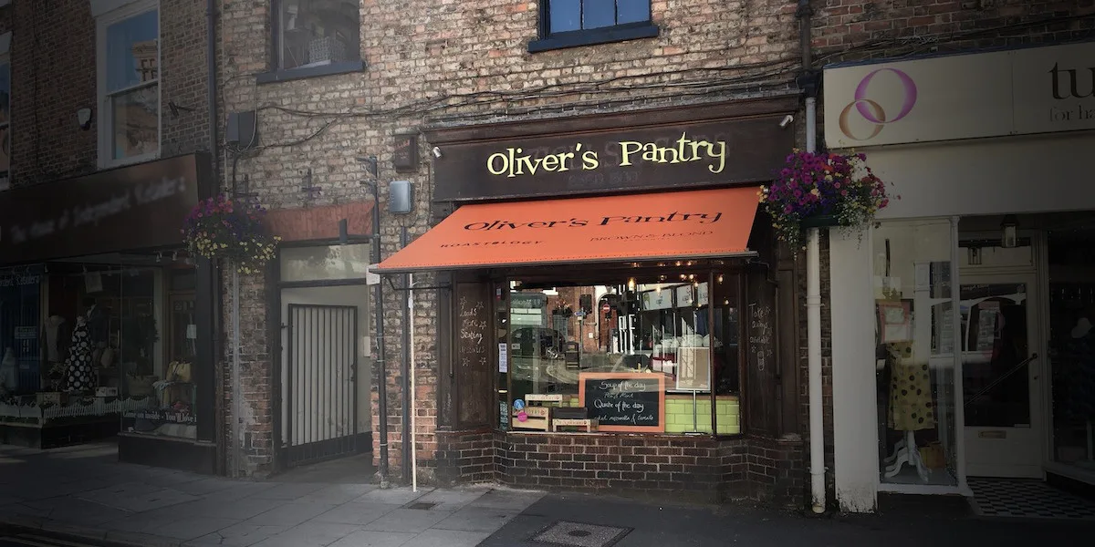 The Oliver's Pantry shopfront on North Street in Ripon, with its orange awning and hanging baskets