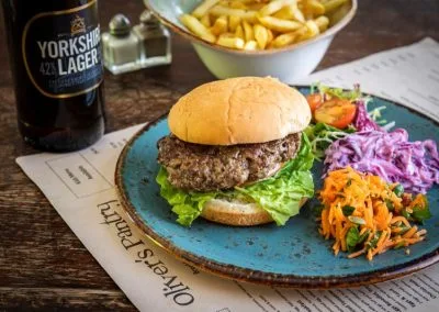 A burger with chips and slaw on a blue plate