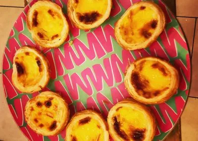 Tray of Portuguese custard tarts on a red patterned plate