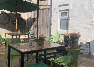 Courtyard table with green chairs and a parasol